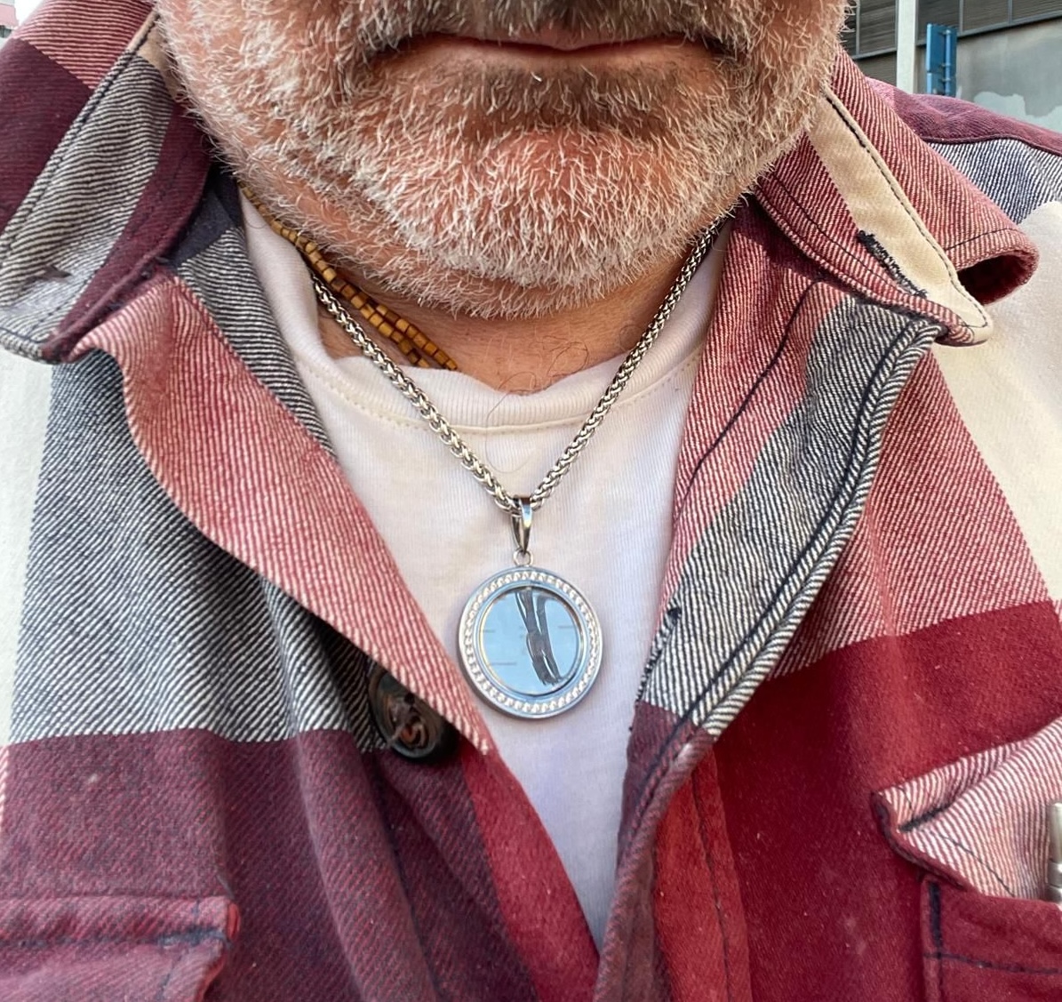 Person wearing medallion necklace